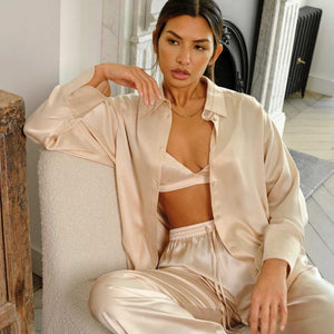 Model wears luxury blush silk shirt and trouser pyjama set by Fleur of England