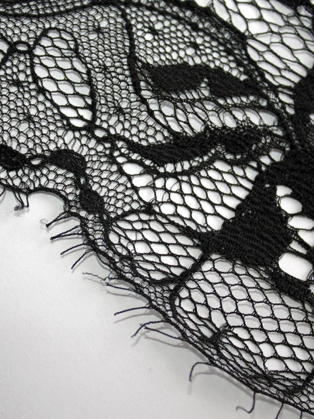 Close up image of black luxury lace with floral detailing by Fleur of England