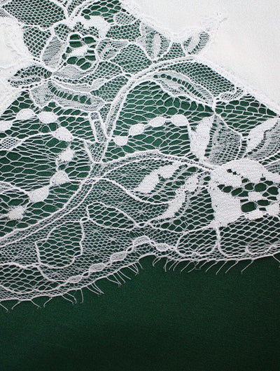 Close up image of white luxury lace with floral detailing by Fleur of England