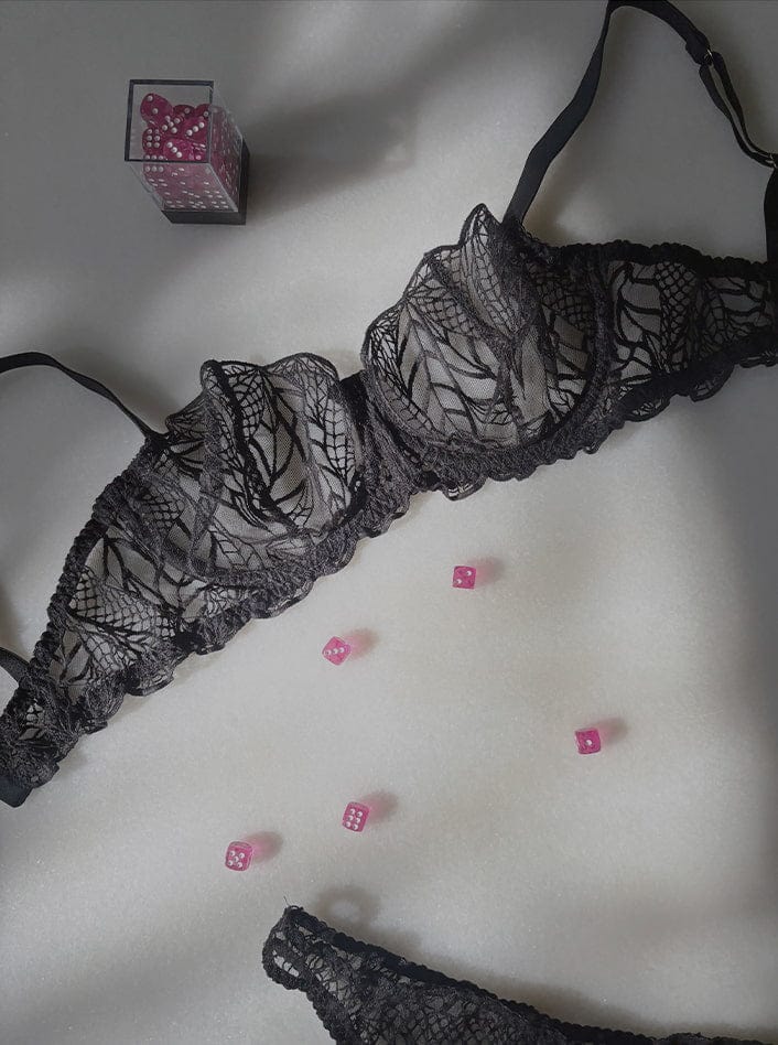 Luxury black lace bra and thong lingerie set for halloween 2025 with dice on a table